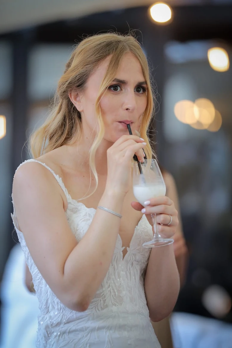 Une mariée savoure une création FOSA Indigo Spirits au vin d'honneur